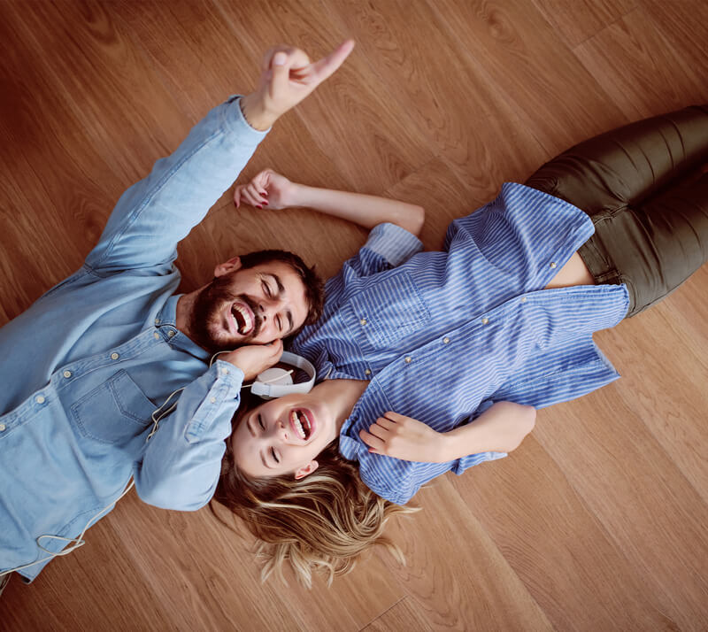 male and female happy laying on newly installed floors rom from Home Floor Designs flooring showroom in INDIANAPOLIS, IN